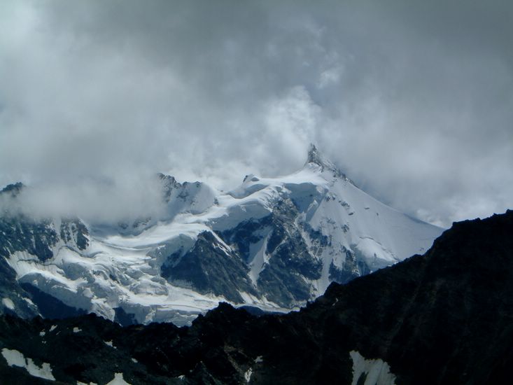 The peak of the Zinal Rothorn emerges from the clouds